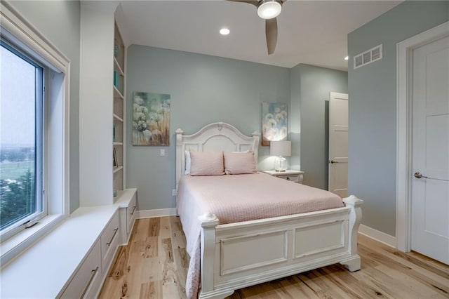 bedroom with light hardwood / wood-style floors, ceiling fan, and multiple windows