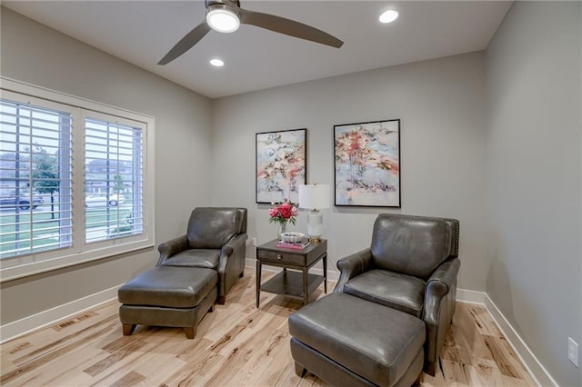 living area featuring ceiling fan and light hardwood / wood-style flooring