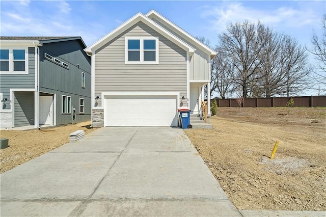 view of front of property with driveway, an attached garage, and fence