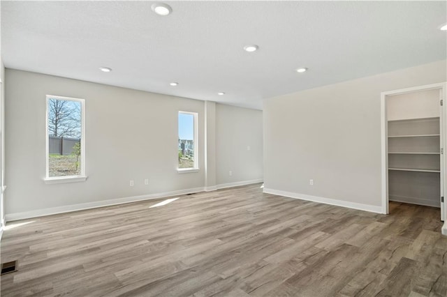 empty room featuring recessed lighting, baseboards, visible vents, and light wood finished floors