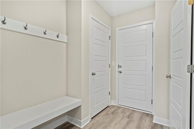 mudroom featuring light wood finished floors and baseboards