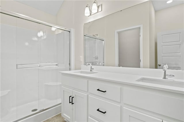 bathroom featuring double vanity, a sink, and a shower stall