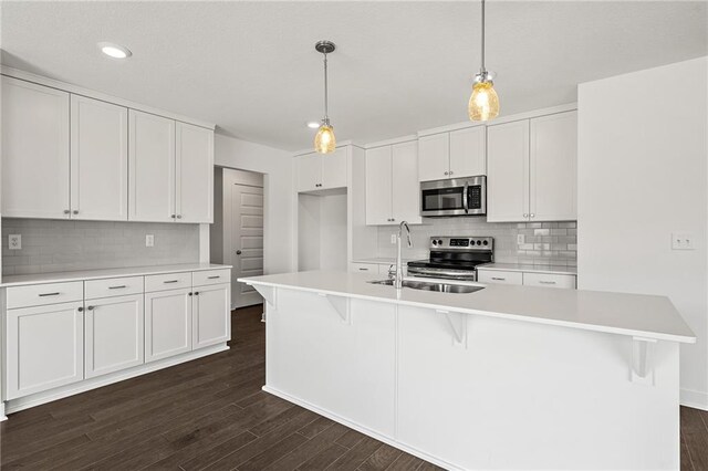 kitchen with white cabinetry, backsplash, sink, and stainless steel appliances