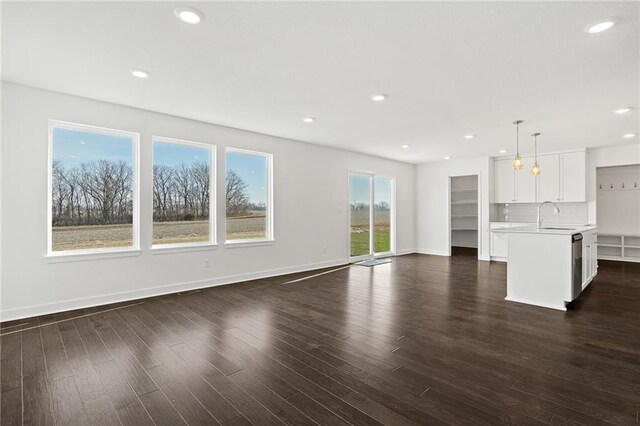 unfurnished living room with dark hardwood / wood-style flooring and sink