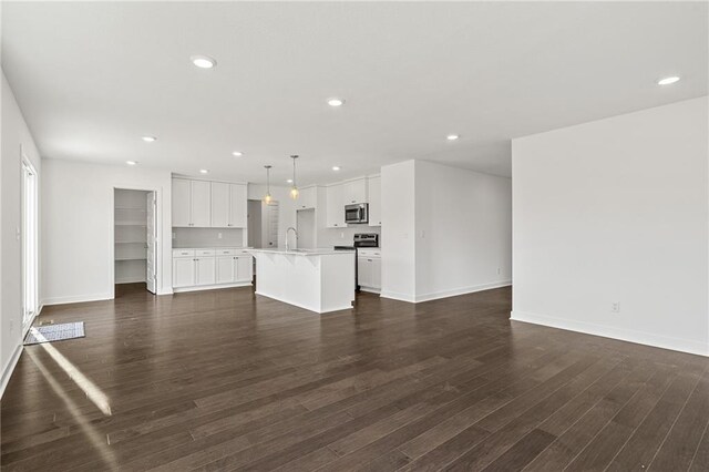 unfurnished living room featuring dark hardwood / wood-style floors and sink