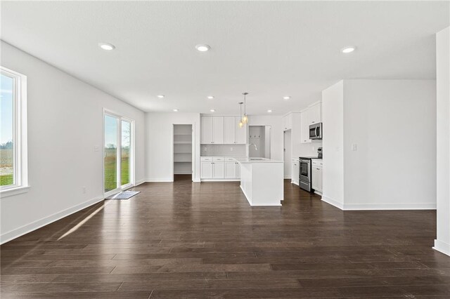 unfurnished living room featuring sink and dark wood-type flooring