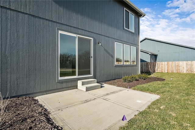 property entrance with a patio area and a lawn