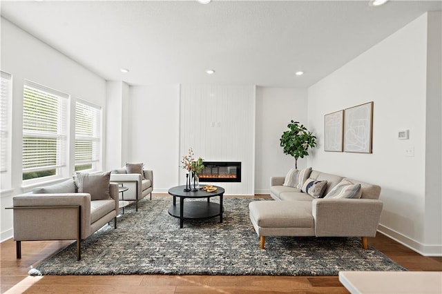 408 Woodview Dr, Raymore, MO 64083 - living area with wood finished floors, a glass covered fireplace, baseboards, and recessed lighting