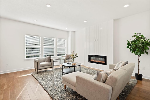 408 Woodview Dr, Raymore, MO 64083 - living area with a large fireplace, hardwood / wood-style floors, baseboards, and recessed lighting