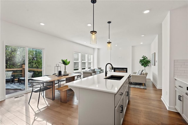 408 Woodview Dr, Raymore, MO 64083 - kitchen with a sink, open floor plan, light countertops, healthy amount of natural light, and recessed lighting