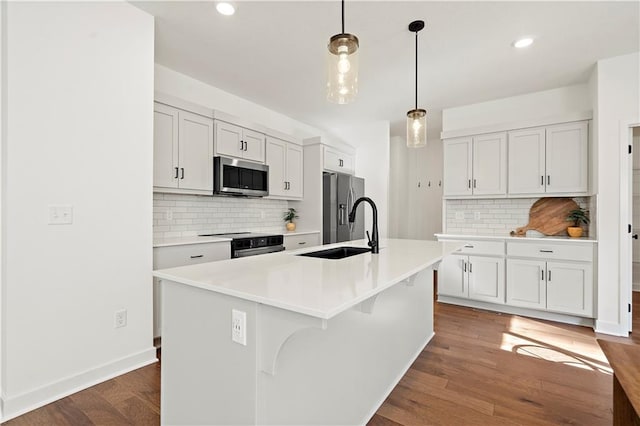408 Woodview Dr, Raymore, MO 64083 - kitchen with appliances with stainless steel finishes, a sink, decorative backsplash, light countertops, and dark wood-type flooring