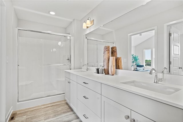 408 Woodview Dr, Raymore, MO 64083 - full bath featuring a stall shower, wood finished floors, and double vanity