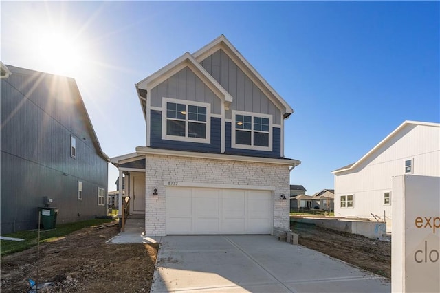 view of front of house with a garage, driveway, board and batten siding, and stone siding