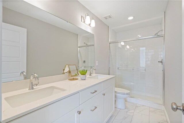 bathroom featuring tile patterned floors, walk in shower, dual vanity, and toilet