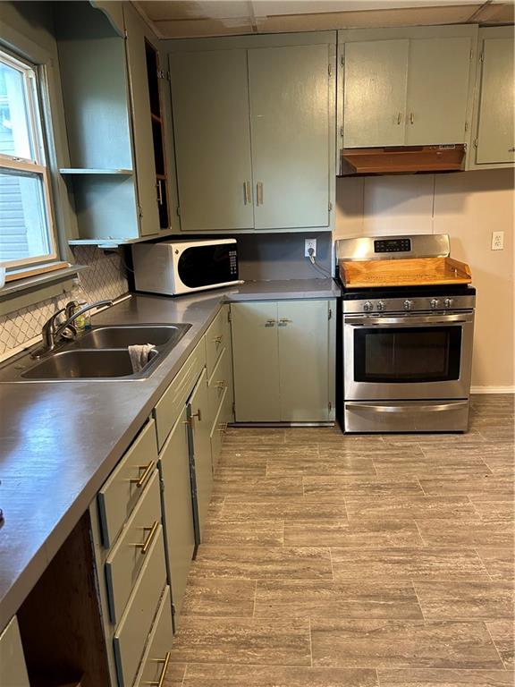 kitchen with sink, stainless steel range, and backsplash