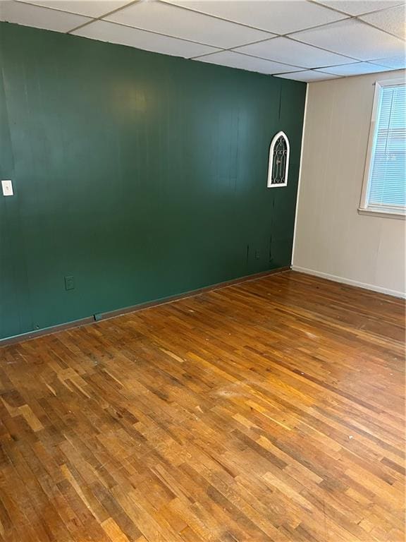 unfurnished room featuring a paneled ceiling and wood-type flooring