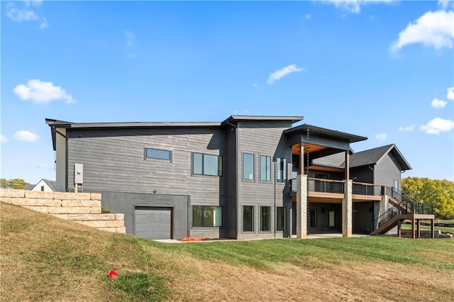 back of property featuring a garage and a lawn