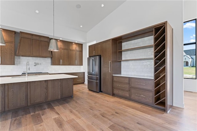 kitchen featuring stainless steel fridge, pendant lighting, plenty of natural light, and backsplash