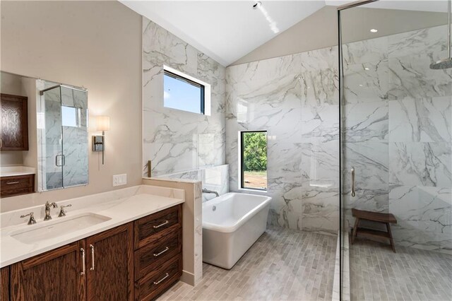 bathroom featuring lofted ceiling, tile walls, vanity, and independent shower and bath