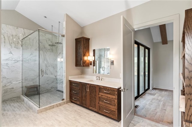 bathroom featuring lofted ceiling, a shower with door, hardwood / wood-style floors, and vanity