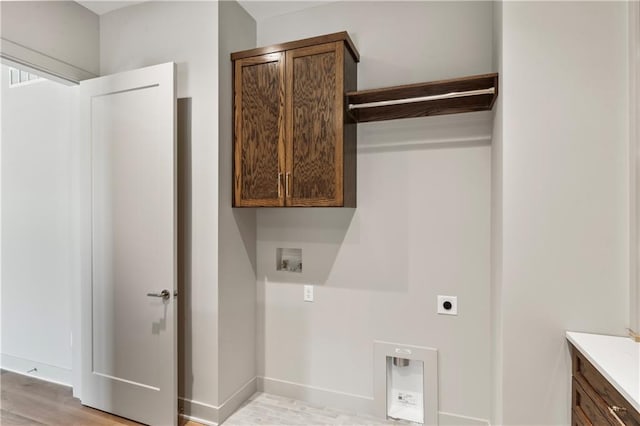 clothes washing area with washer hookup, cabinets, light hardwood / wood-style flooring, and electric dryer hookup