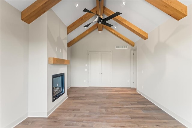 unfurnished living room featuring light hardwood / wood-style floors, beamed ceiling, high vaulted ceiling, and ceiling fan