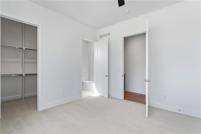 unfurnished bedroom with ceiling fan, a closet, and light colored carpet