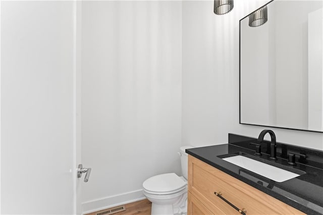 bathroom featuring vanity, toilet, and hardwood / wood-style flooring