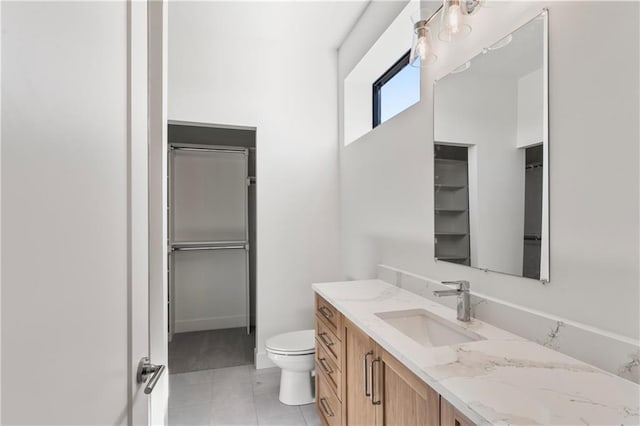 bathroom featuring vanity, tile patterned flooring, and toilet