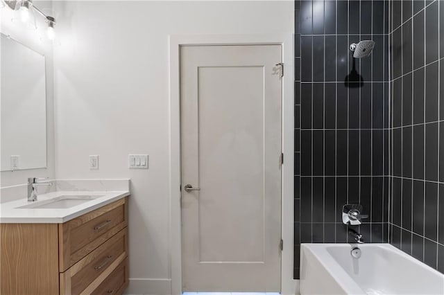 bathroom featuring vanity and tiled shower / bath