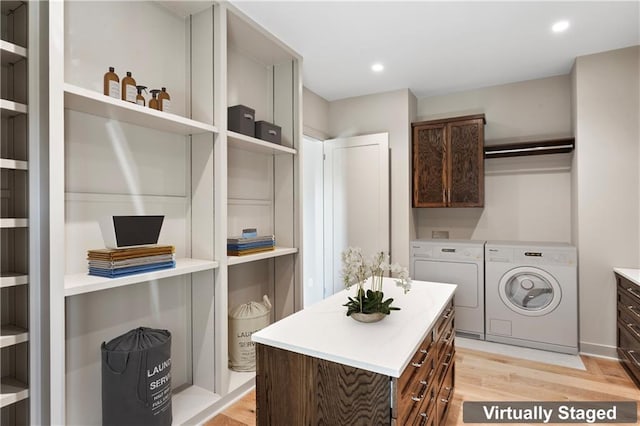 laundry area with light hardwood / wood-style flooring, cabinets, and separate washer and dryer