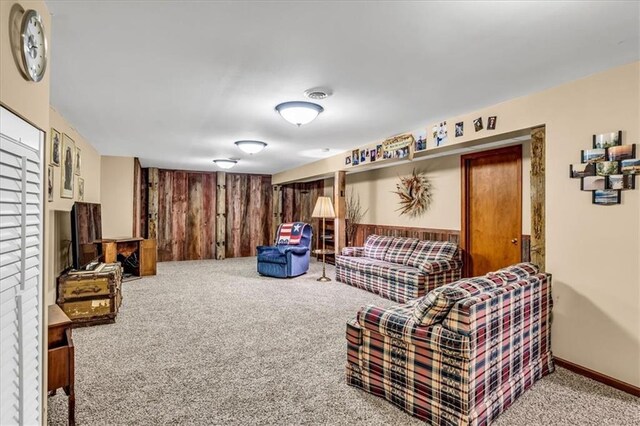 carpeted living room with wooden walls