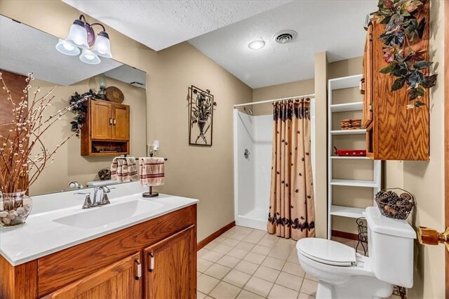 bathroom with curtained shower, vanity, a textured ceiling, toilet, and tile patterned floors