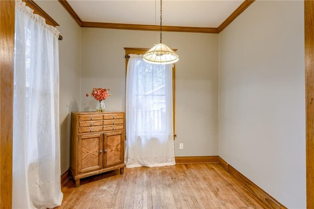 empty room with crown molding and light hardwood / wood-style flooring