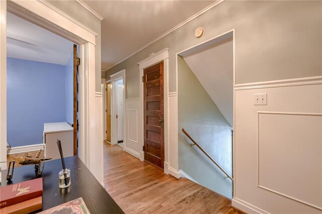 hall featuring ornamental molding and light hardwood / wood-style floors