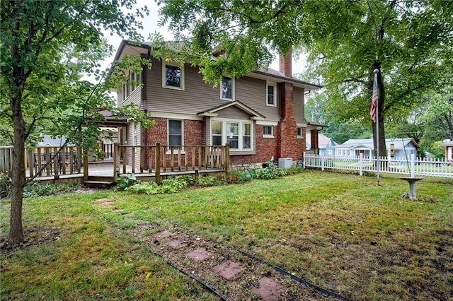 back of house with a yard and a wooden deck