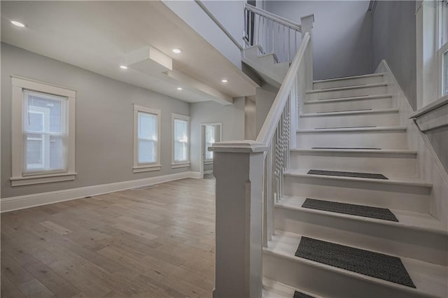 staircase with hardwood / wood-style floors and a healthy amount of sunlight