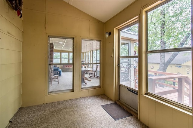 entryway featuring lofted ceiling and light carpet