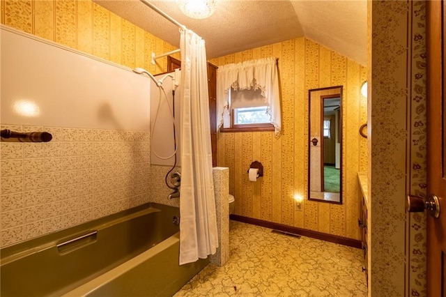 bathroom with a textured ceiling, shower / bath combination with curtain, vaulted ceiling, and toilet