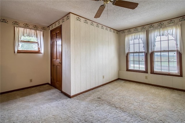 unfurnished room with a textured ceiling, plenty of natural light, and ceiling fan