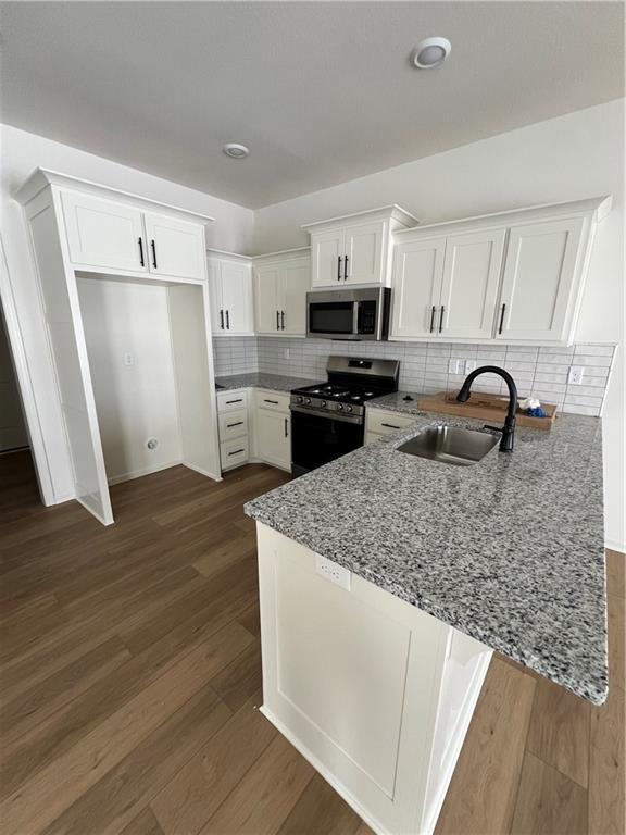 kitchen featuring white cabinets, kitchen peninsula, and stainless steel appliances