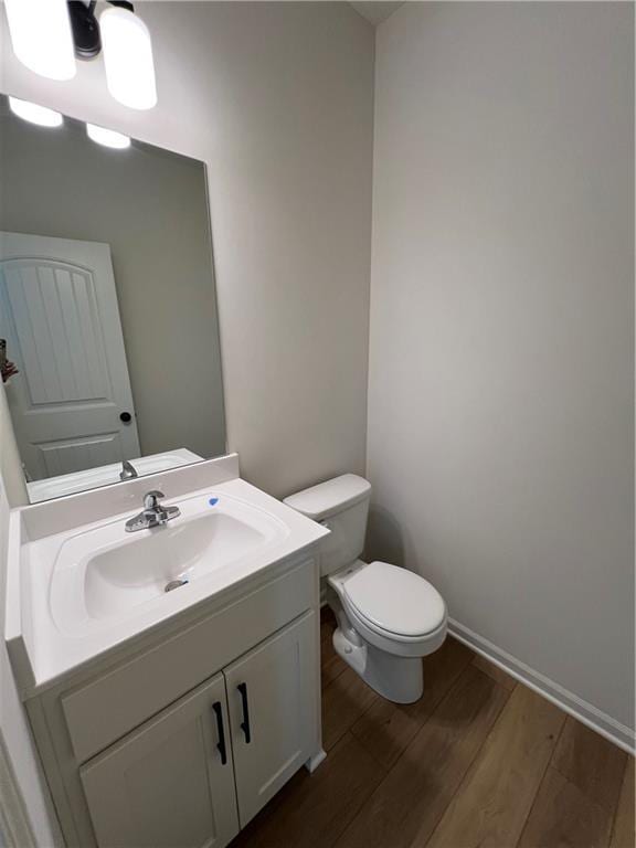 bathroom featuring vanity, wood-type flooring, and toilet