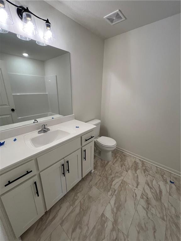 bathroom featuring vanity, toilet, and walk in shower