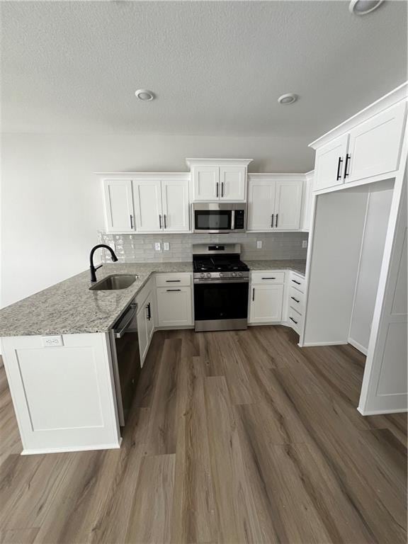 kitchen featuring backsplash, sink, white cabinetry, and stainless steel appliances