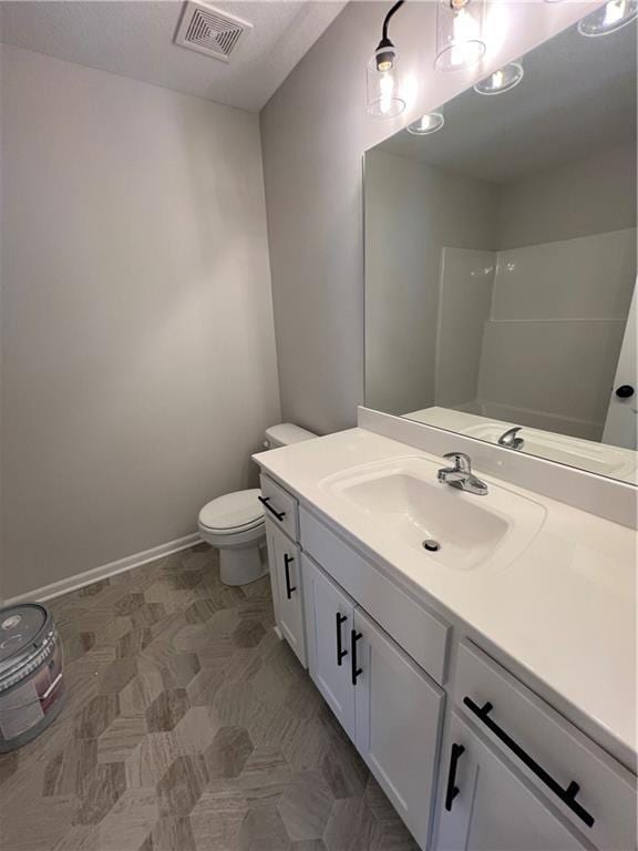 bathroom with vanity, toilet, and walk in shower