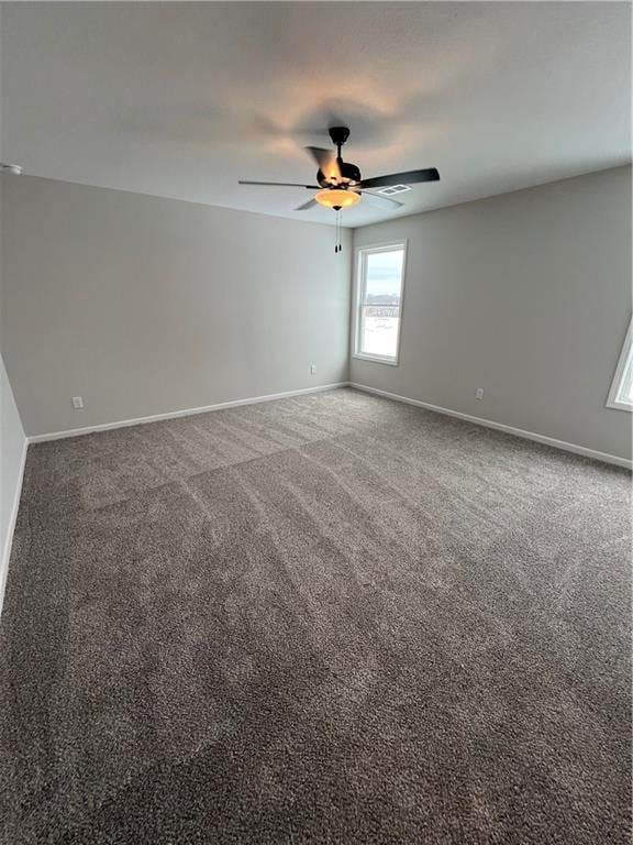 carpeted spare room with ceiling fan