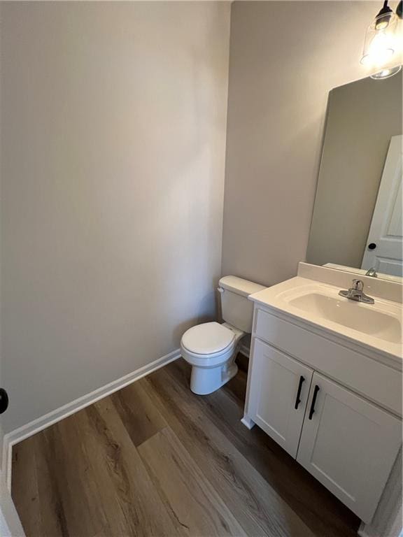 bathroom with hardwood / wood-style floors, vanity, and toilet