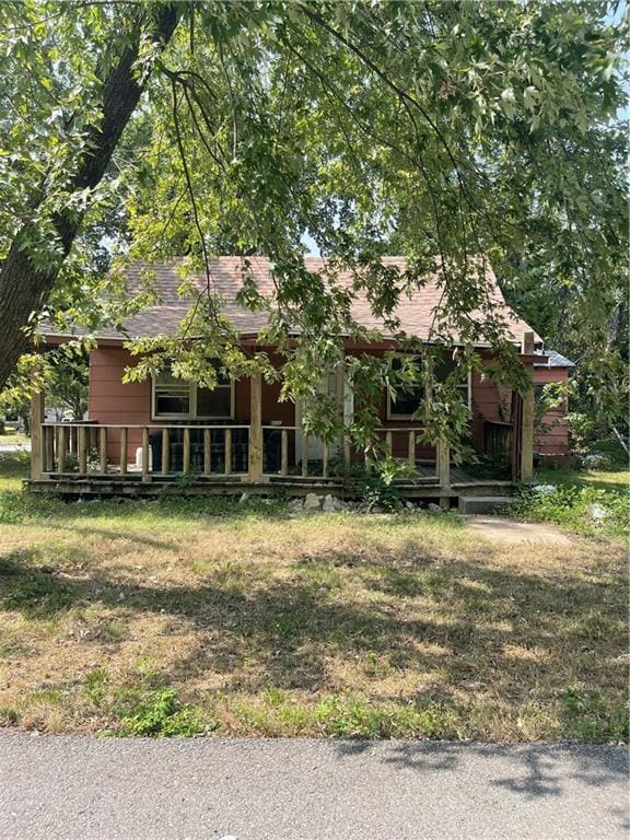 view of property hidden behind natural elements with a front yard