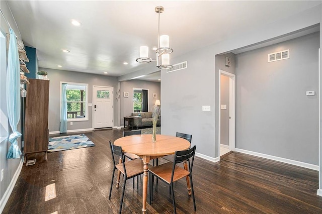 dining area with wood finished floors, visible vents, and baseboards