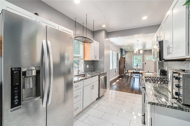 kitchen featuring a sink, tasteful backsplash, appliances with stainless steel finishes, and white cabinets